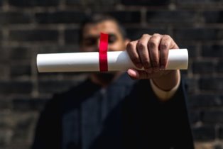 student-outside-holding-out-diploma_4460x4460